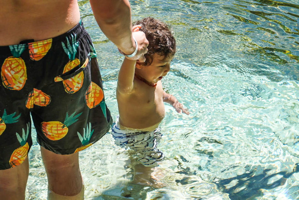 Dad holding toddler hand Cenote Azul pool