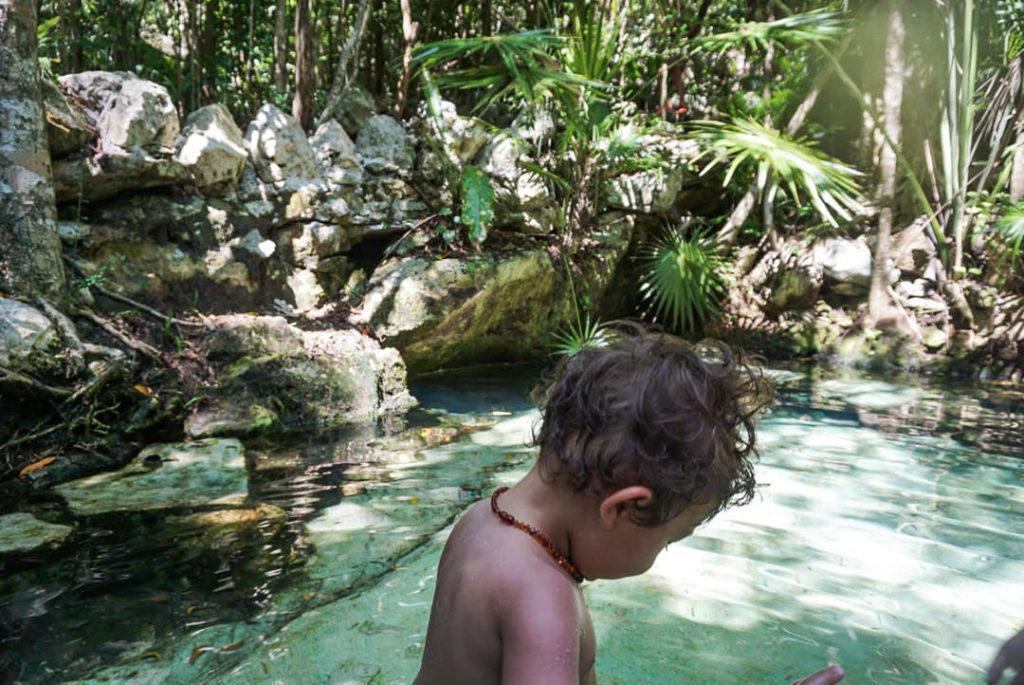 Toddler in light aqua water Cenote Azul pool