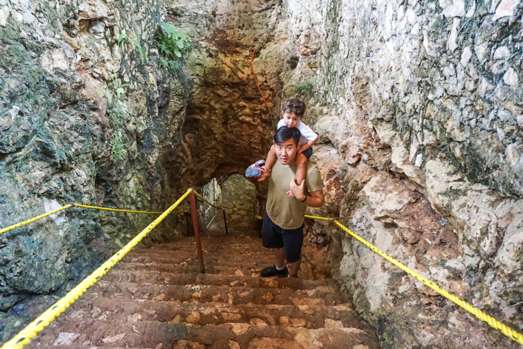 Dad and toddler on the stairs leading down into Cenote Suytun