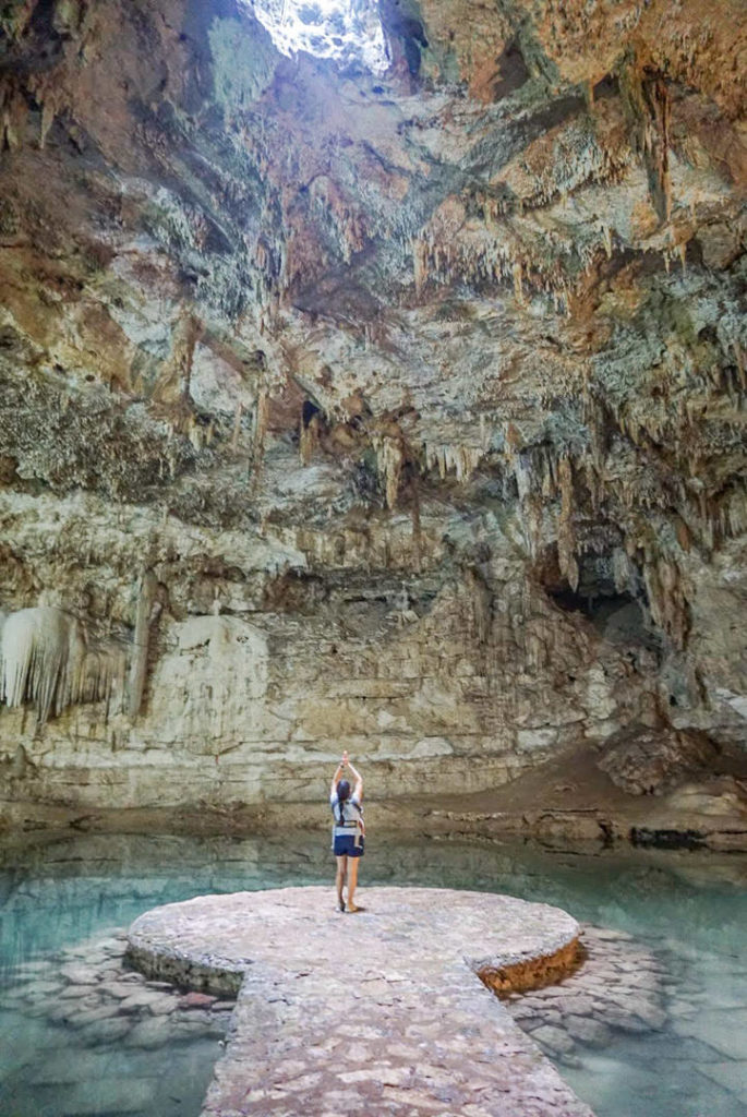 Mom with baby carrier sun salutation middle platform Cenote Suytun