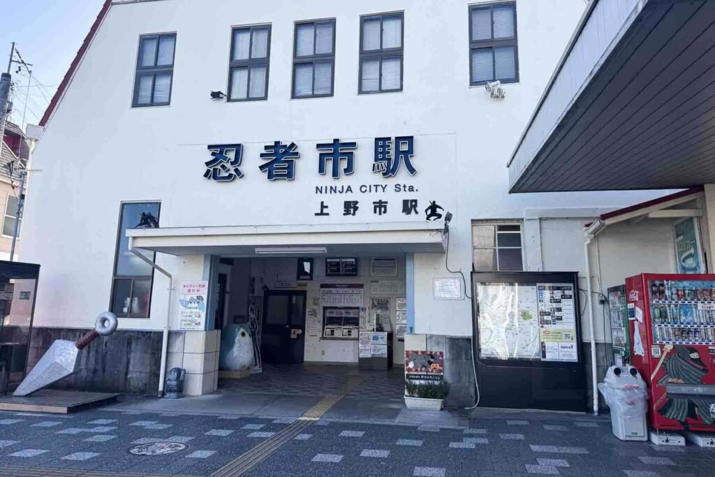 Exterior of Ninja City (Uenoshi) Station in Iga, Japan, featuring playful ninja statues and signage in both Japanese and English. Visiting this themed train station gets kids excited for a day trip to Iga.