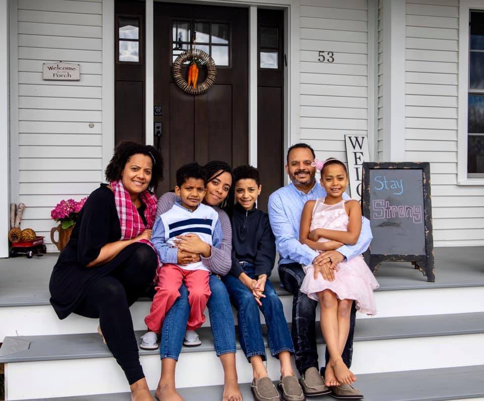 Black multiethnic family in front of house