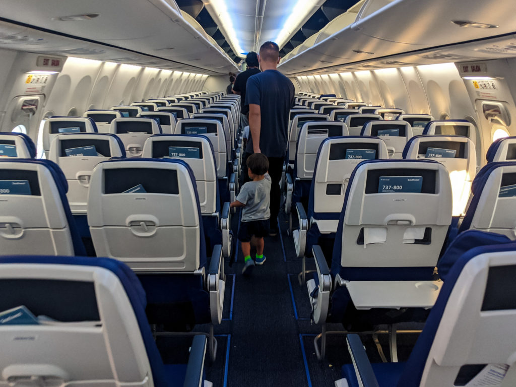 Dad holding toddler's hand walking off plane