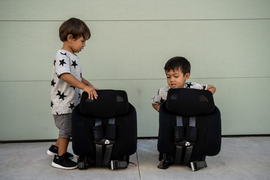 Toddler brothers checking out their new compact folded WAYB Pico travel car seats