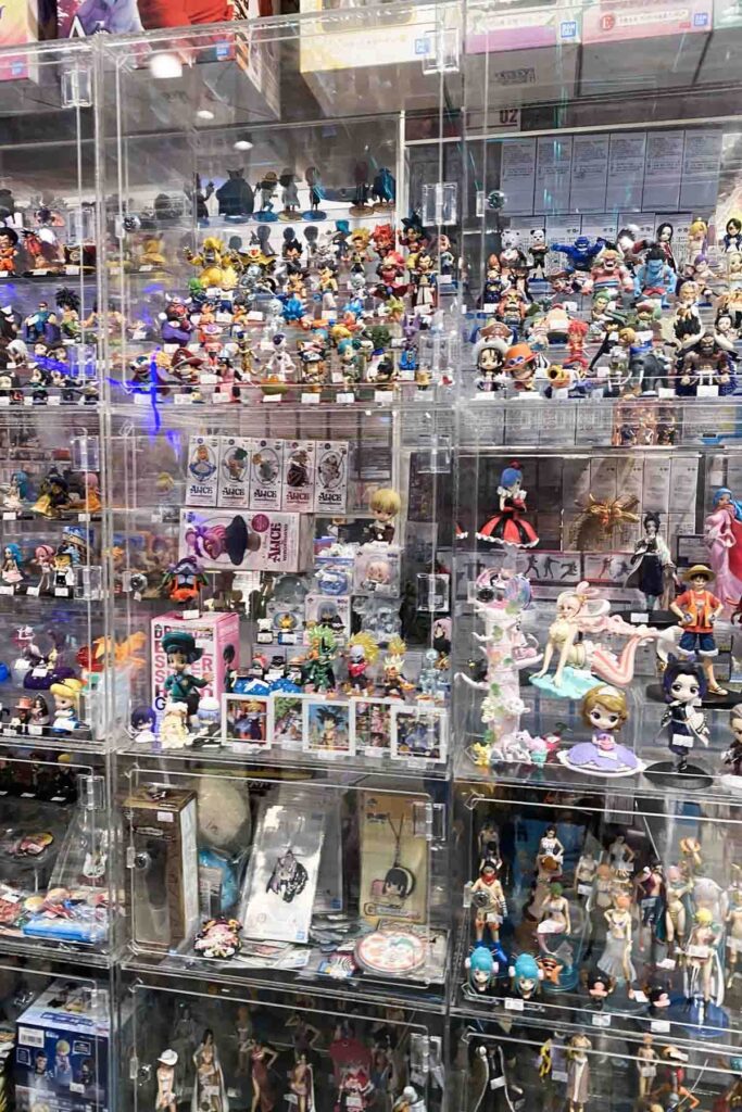 Dozens of detailed anime figurines and character models are tightly packed in transparent display cases, including characters from various popular series and collectible packaging in Taipei, Taiwan.