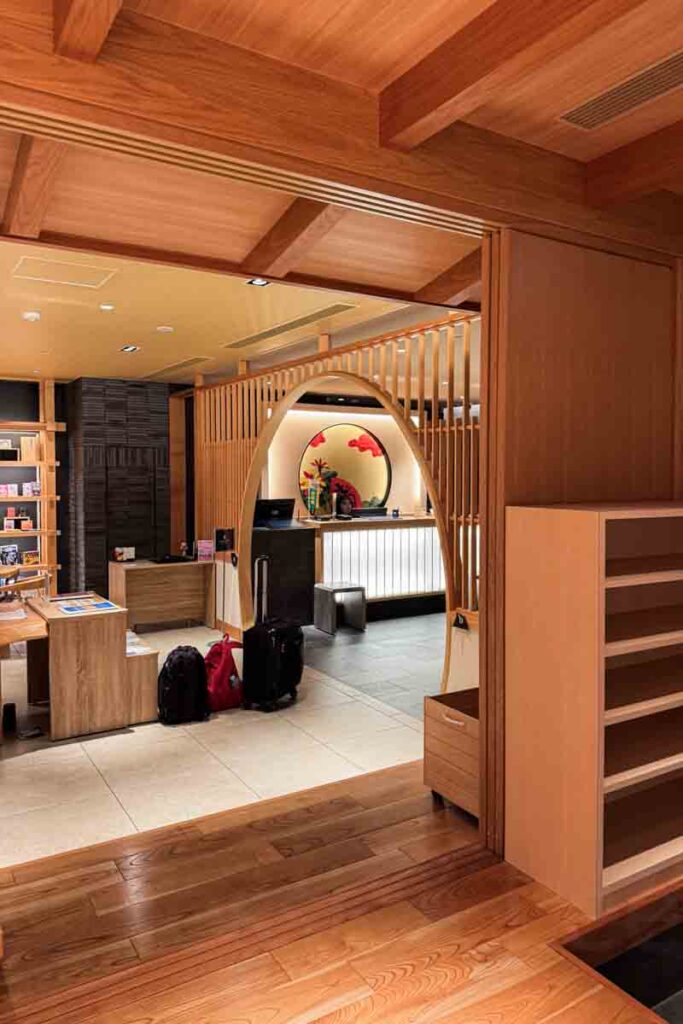 The hotel lobby in Osaka at Mimaru Namba Station features warm wood paneling and a welcoming archway, setting a calm tone for families arriving with kids.
