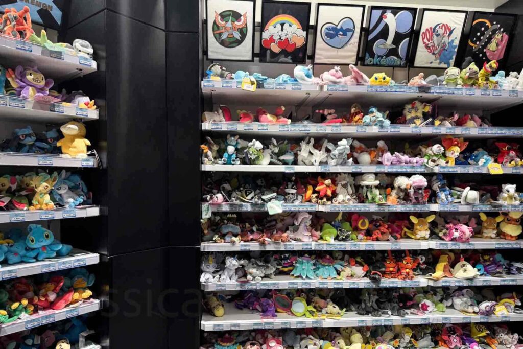 Shelves stacked with small colorful Pokémon plush toys line the walls of the Pokémon Center in Shibuya Parco, including Pikachu, Eevee, and Lucario.