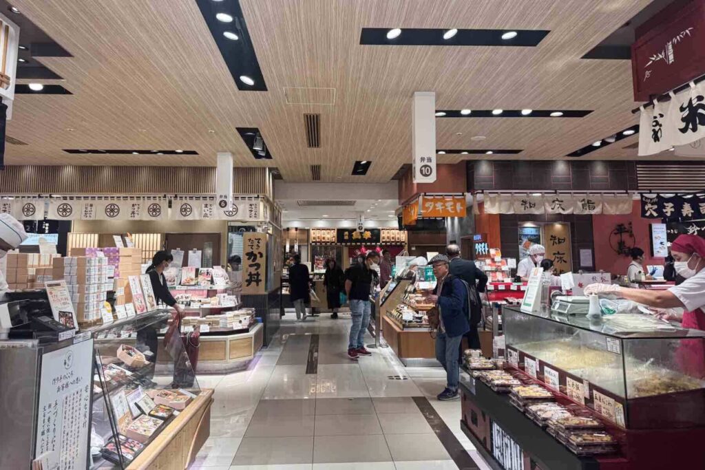 Shoppers browse rows of beautifully packaged food and bento boxes inside a Tokyo Station’s underground food floor market. Exploring these gourmet markets is a fun thing to do before or after a train ride.