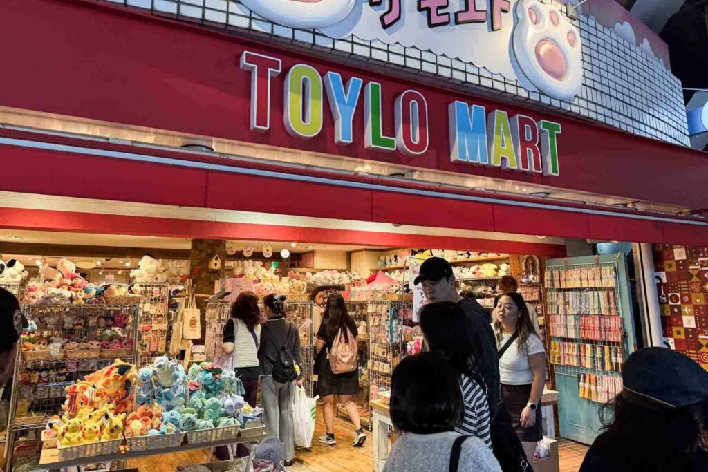 The colorful exterior of Toylo Mart in Tokyo is filled with plush toys and character goods, drawing in a crowd of shoppers in Harajuku district. A perfect stop when visiting Tokyo with kids who love kawaii souvenirs.