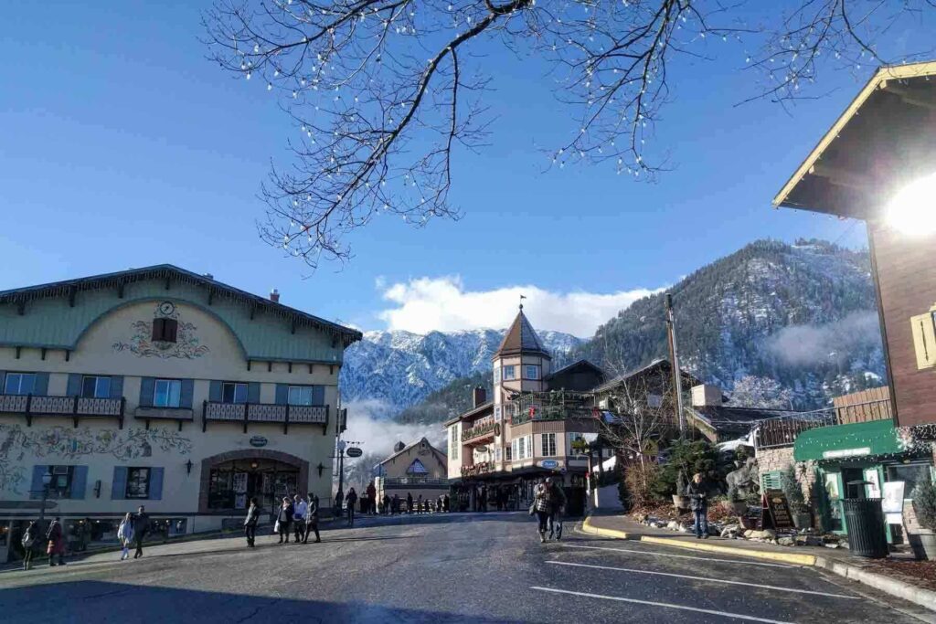 People stroll through the Bavarian-style streets of downtown Leavenworth, Washington, with painted facades and snow-capped mountain views. This festive village is one of the most magical Christmas destinations in the U.S. - a treat with kids.
