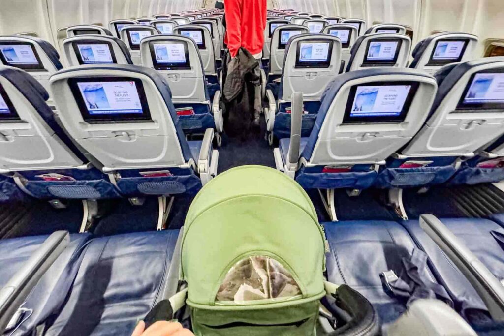 Babyzen Yoyo stroller rolling down an airplane aisle on a Delta flight, showing the stroller’s small footprint, flexibility and real world deplaning with baby travel stuff and a compact stroller.