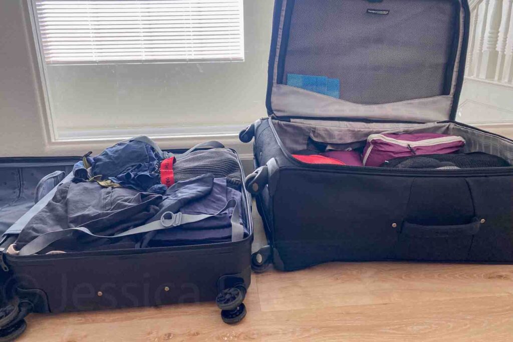 Two open black suitcases sit side by side in front of a bright window with one using packing cubes and the other loosely packed. The comparison highlights packing tips for family vacation travel and how packing cubes keep items more organized.