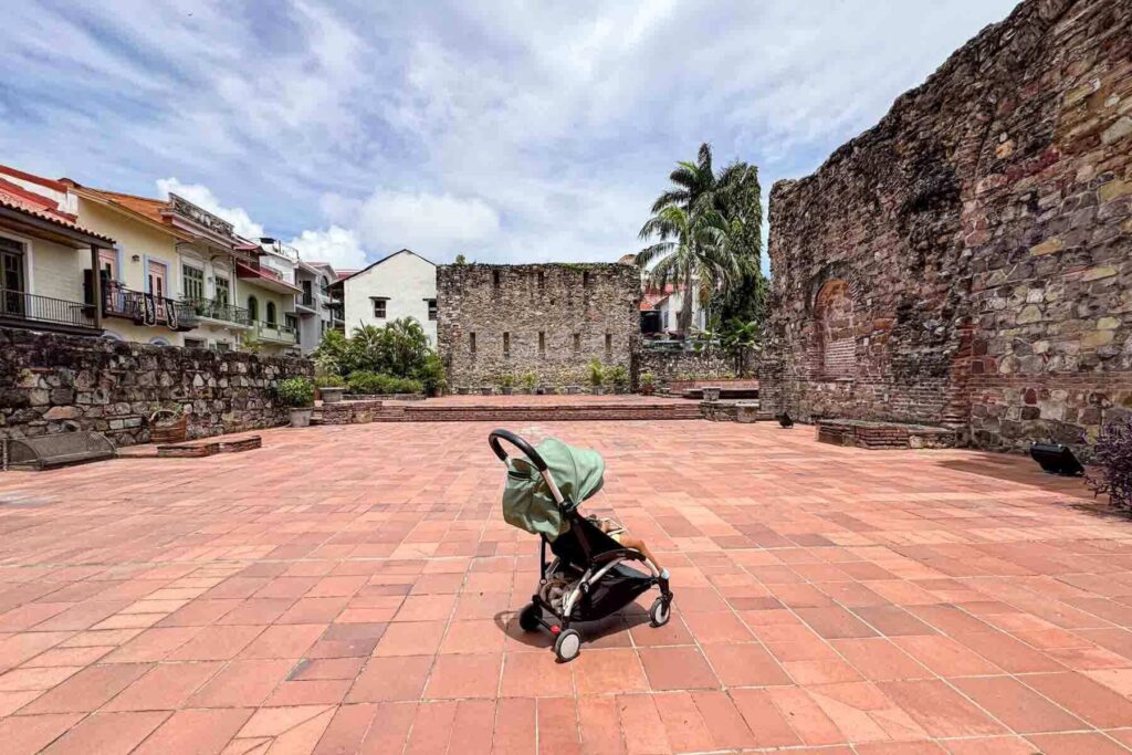 Babyzen Yoyo stroller in a historic plaza with old stone walls and red tile flooring of Arco Chato in Casco Vieja, Panama City, showing maneuverability for sightseeing.
