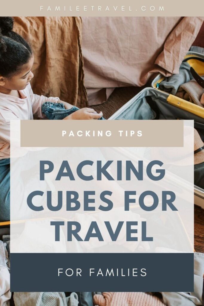 A child sits beside an open suitcase while packing clothes with packing cubes. Text on the image reads Packing Tips / Packing Cubes for Travel / for Families. This graphic image meant for Pinterest is helping promote the blog post for packing cubes for family travel.