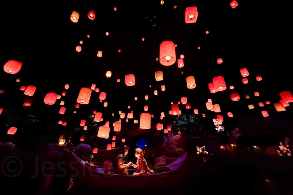 Indoor boat ride scene at Tokyo DisneySea with glowing lanterns floating overhead in a dark room. The Rapunzel floating lantern ride is a magical highlight for many families visiting Japan with kids.