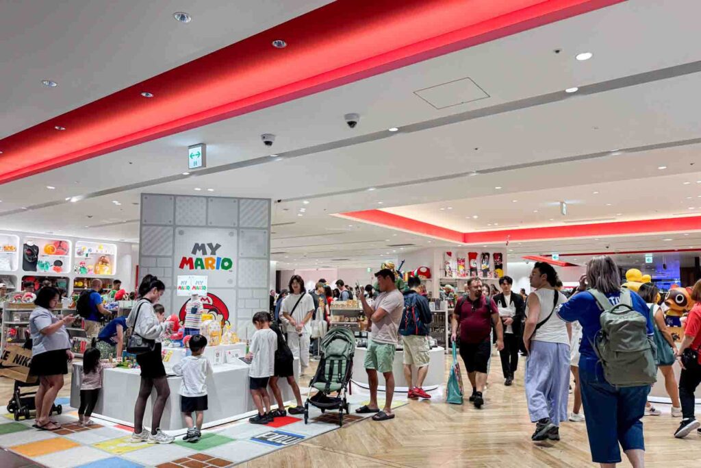 Busy interior of Shibuya Parco shopping mall with visitors browsing the "MY MARIO" Nintendo themed store. Pop culture shopping stops like this are popular when traveling with kids to Japan.