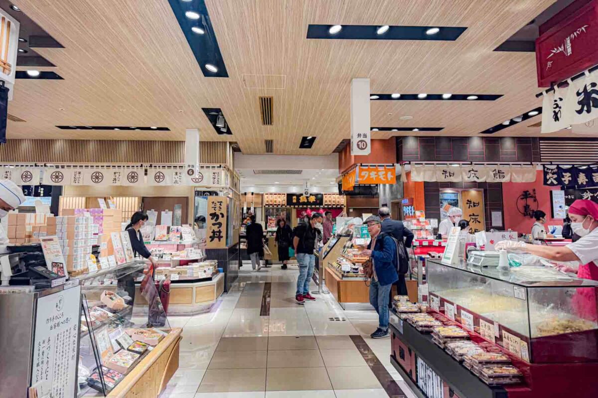 Bright indoor market inside Tokyo Station with prepared foods, bento boxes, and shoppers moving between stalls. A practical option for quick meals to-go with kids in Japan.