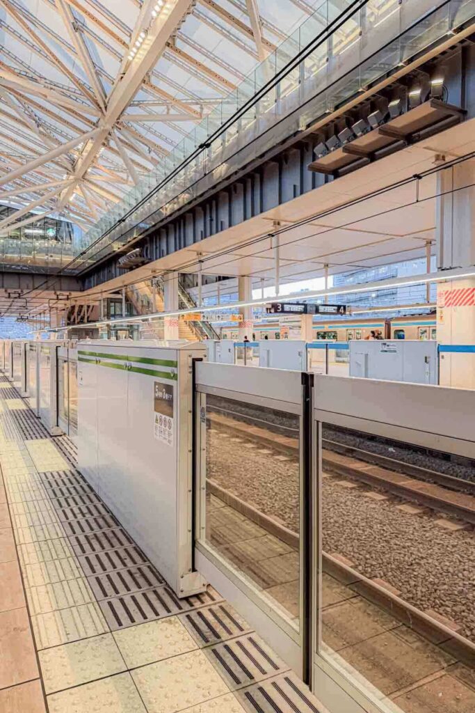 Modern and bright Tokyo metro station platform with glass safety barriers and numbered tracks. Staying near transit makes it easier for families to explore Tokyo.
