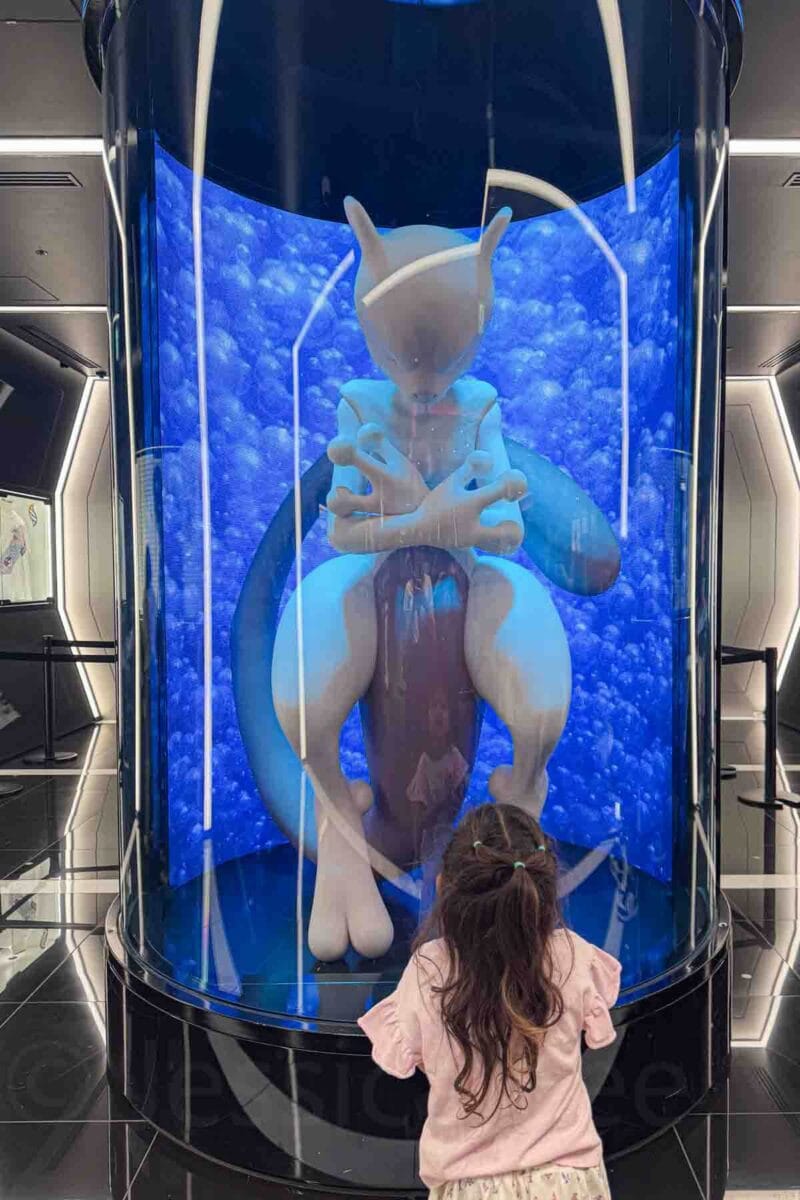 Young child standing in front of a large Mewtwo display inside the Pokémon Center at Parco Shibuya in Tokyo. Anime and gaming attractions like this are exciting stops for kids visiting Tokyo.