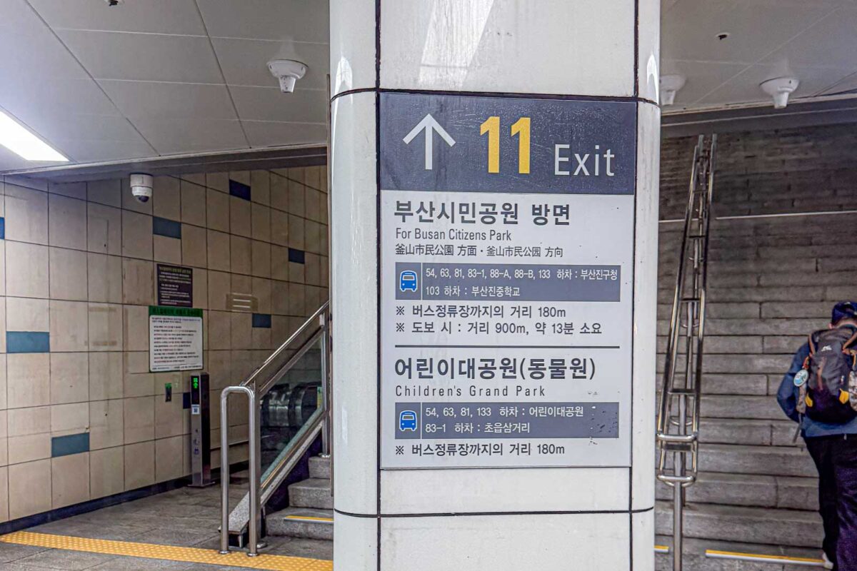 A large Busan Metro sign beside stairs marks "11 Exit" and lists directions for "Busan Citizens Park" and "Childrens Grand Park". Attraction specific exit signs can help families avoid unnecessary walking after leaving the Metro.
