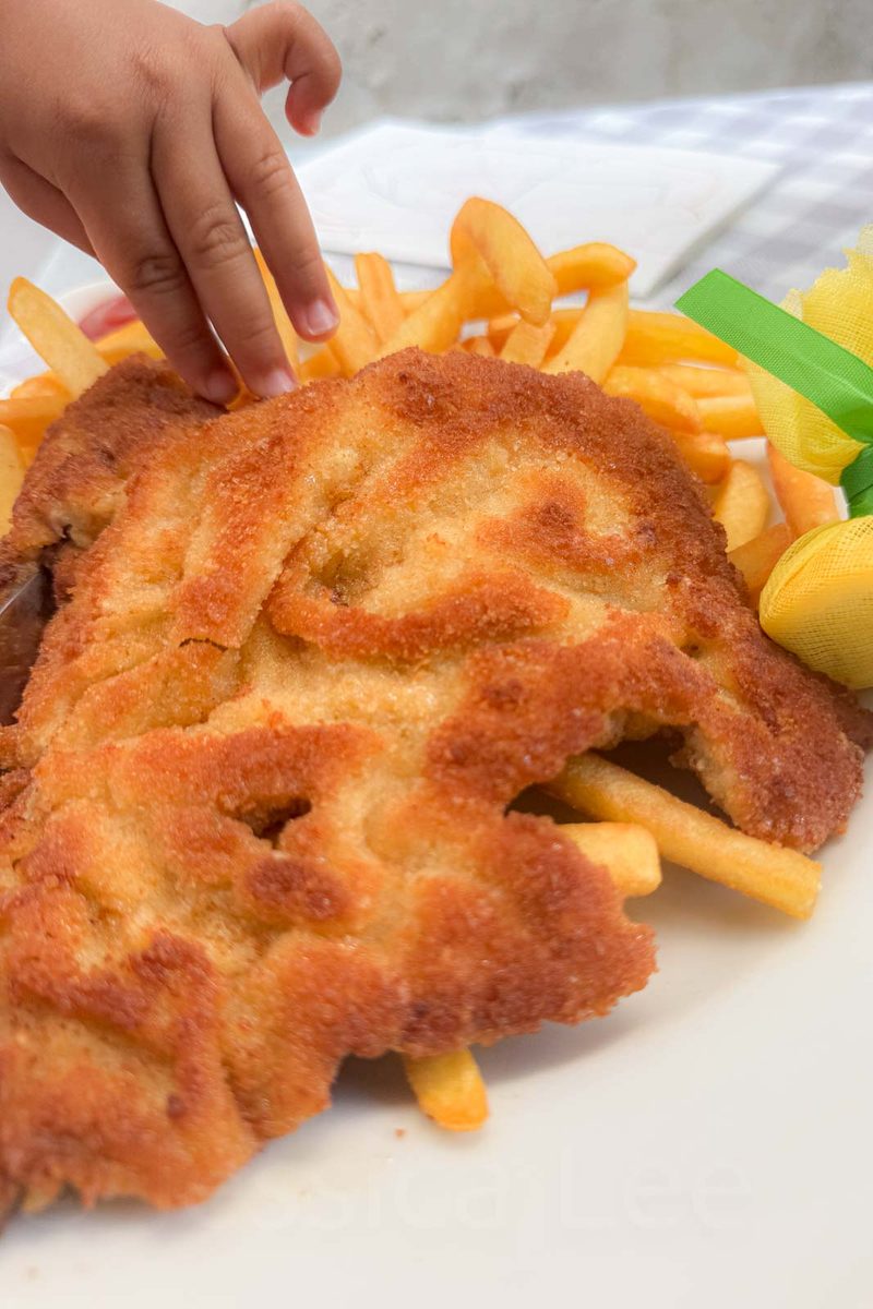A children's meal of schnitzel served with fries in Munich. An example of the familiar Bavarian food options available for families dining out with kids.